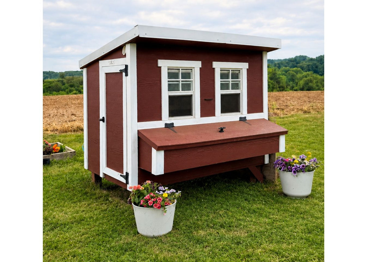 Red large chicken coop with white trim, set up in a backyard