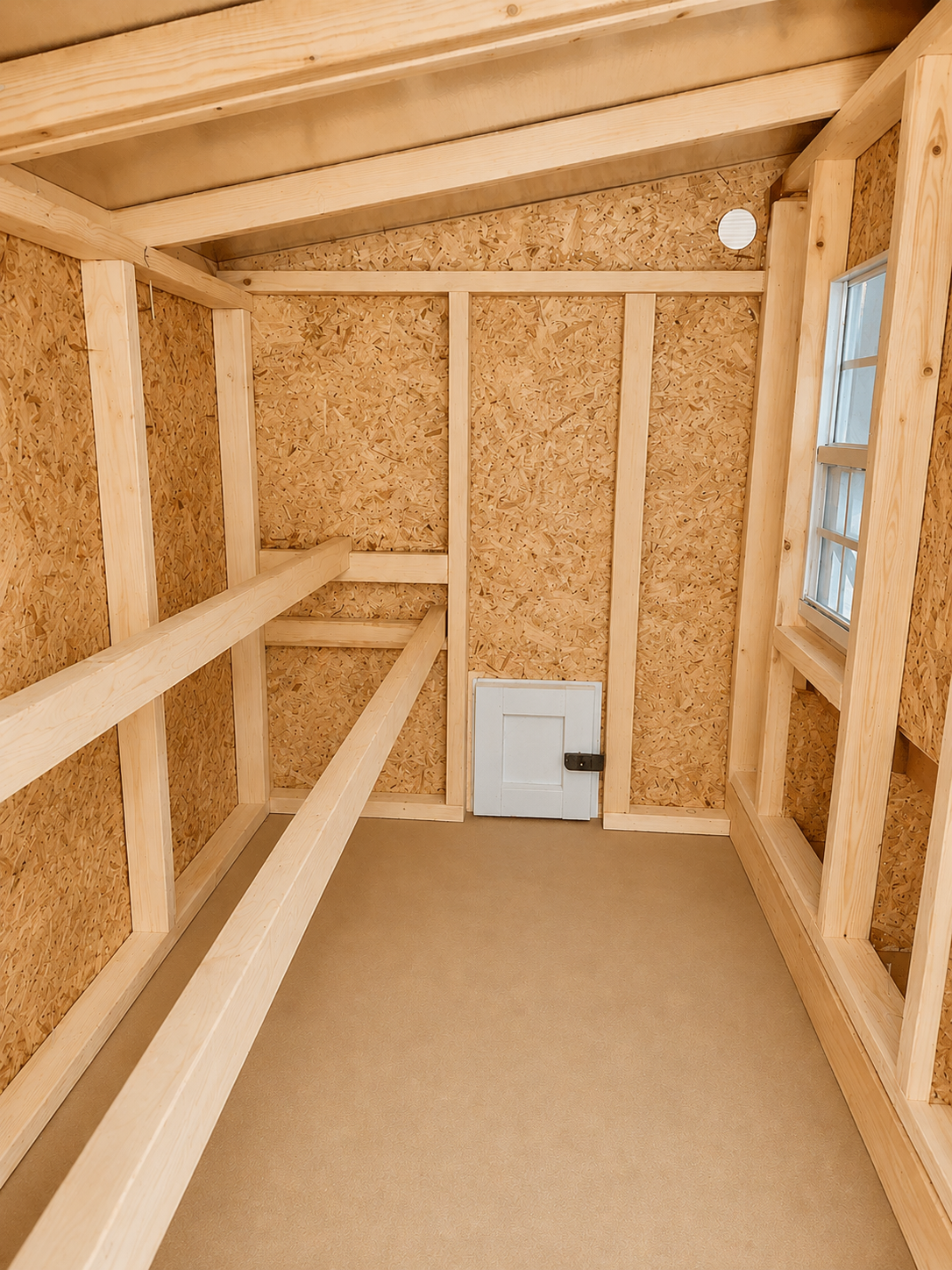 Inside the large chicken coop with roost bars and windows