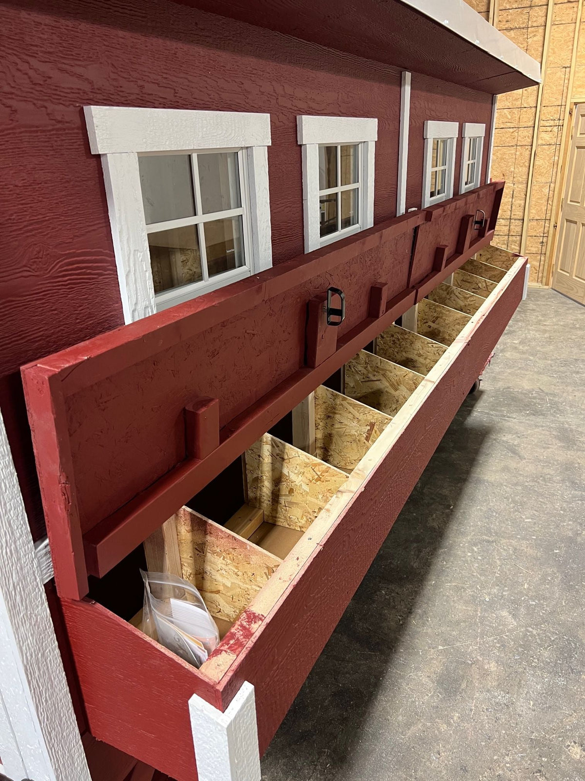 Open nesting boxes on the side of the jumbo chicken coop
