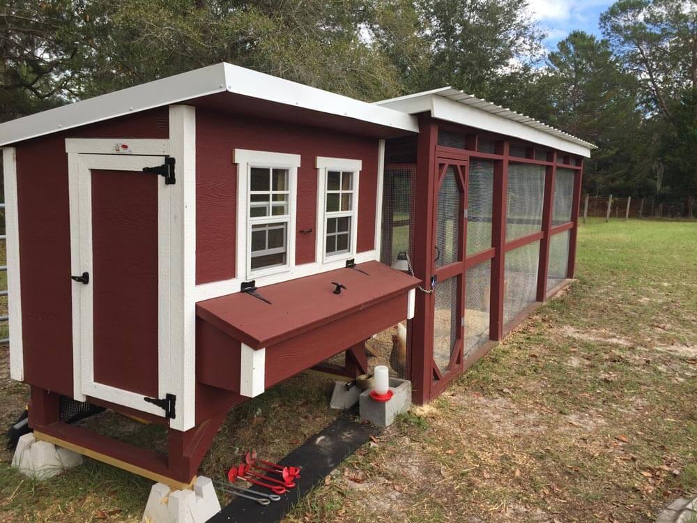 Red large chicken coop with white trim, connected to a walk-in run
