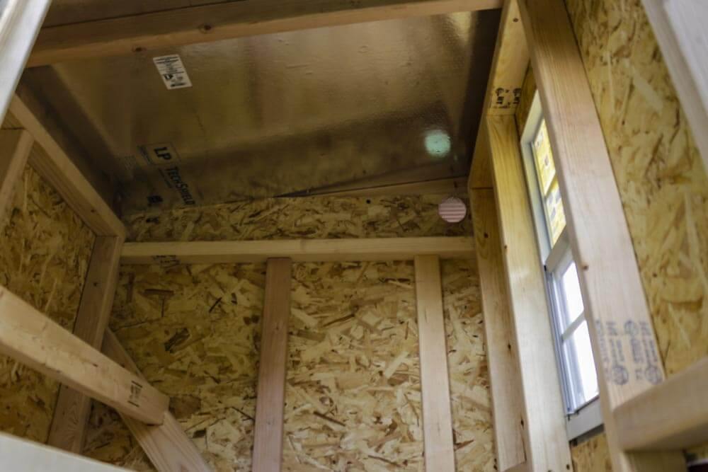 Inside the large chicken coop with roost bars and windows