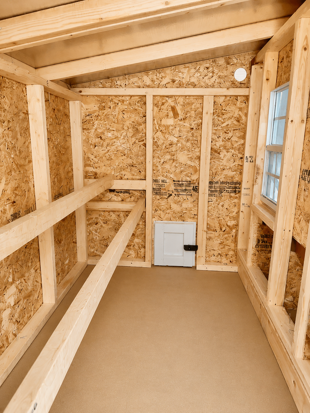 Inside the large chicken coop with roost bars and windows