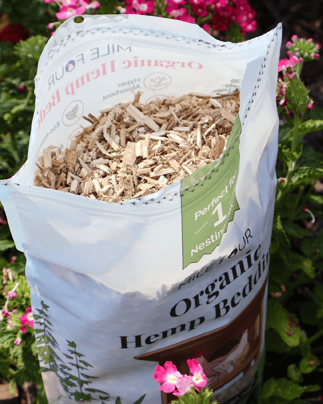 Open bag of organic hemp bedding among flowers