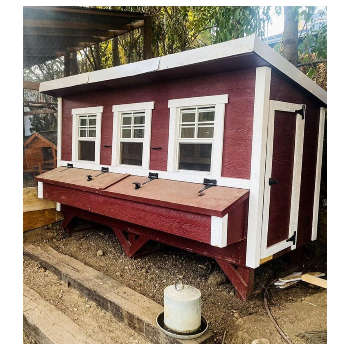 Red XL chicken coop with white trim, set up in a backyard